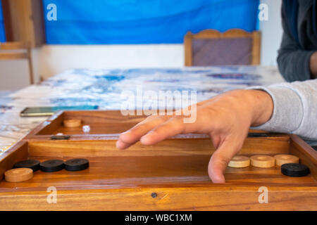Playing backgammon on a wooden table with dices. Stock Photo
