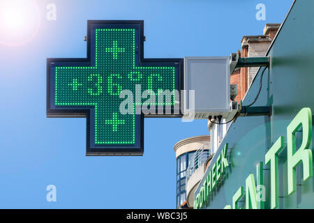 Thermometer in green pharmacy screen sign displays extremely hot temperature of 36 degrees Celsius / 36°C / 36 °C during summer heatwave / heat wave Stock Photo