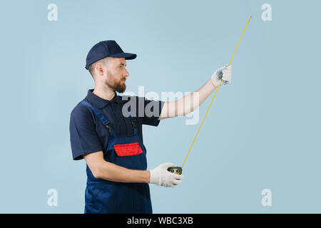 Portrait of a serious service worker with tape-meter in hands dressed in uniform Stock Photo