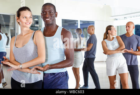 Young happy cheerful positive  people practicing passionate samba in dance class Stock Photo