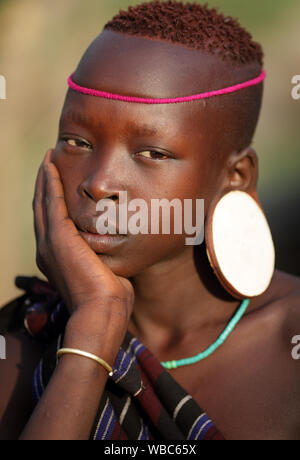 Beautiful young tribal Mursi woman in the Mago National Park, Lower Omo Valley, Ethiopia Stock Photo