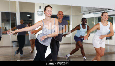 Group of multinational positive people practicing new dance techniques in modern class Stock Photo