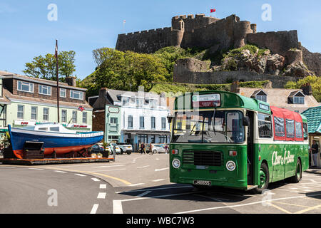 A Charabanc of the Jersey Bus and Boat Tours company stopped at Gorey Pier below Mont Orgueil Castle, Jersey Stock Photo
