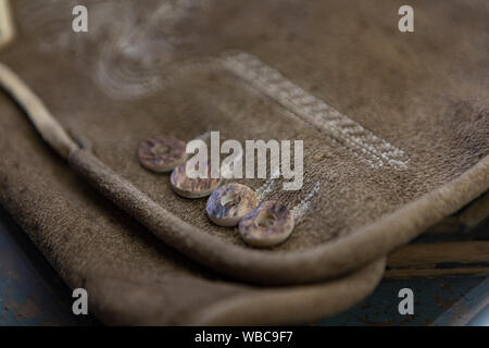 close up of an alpine leather trouser with stag horn button Stock Photo