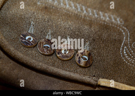 close up of an alpine leather trouser with stag horn button Stock Photo