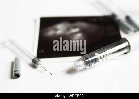 In Vitro Fertilization injection pen. IVF treatment drugs, syringes, needles and pills.  IVF spelled with syringes Stock Photo