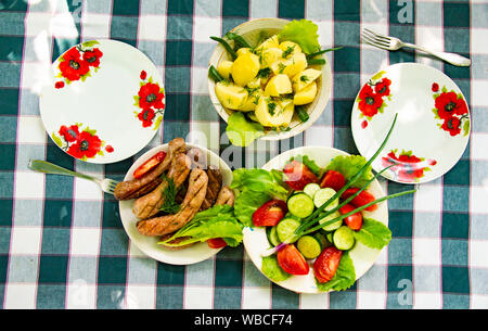 Dishes on the table - vegetables, potatoes, Bavarian sausages. Background. Stock Photo