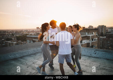 Fitness, sport, training and healthy lifestyle concept - group of happy people exercising outdoor Stock Photo