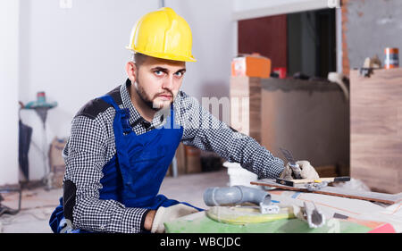 happy builder is preparing for repair in the room at object. Stock Photo
