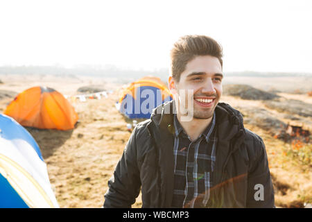 Handsome cheerful man camping outdoors Stock Photo