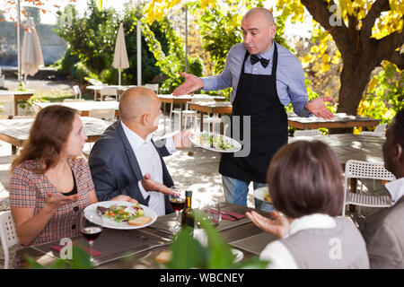 Restaurant guests complain about the food to the waiter Stock Photo