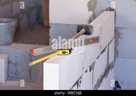 Work tools on a new wall. Building a home concept Stock Photo