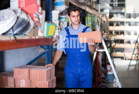 Builder is choosing tiles in the building store. Stock Photo