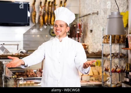 Adult male seller in his grocery shop welcoming customers Stock Photo