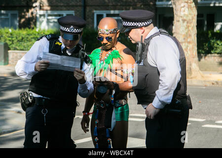 Notting Hill, London, UK. 26th August 2019. A performer is assisted by Polic officers  at  the annual Notting Hill Carnival parade  . More than 2 million people are expected to attend Europe’s biggest street party over two days of the bank holiday weekend Credit: amer ghazzal/Alamy Live News Stock Photo
