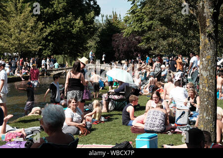 Bourton-on-the-Water, Gloucestershire, UK. 26th August 2019. Crowds are drawn to this Cotswold village to enjoy the cool River Windrush on this very hot Bank Holiday Monday. The village attracts many visitors but is especially busy today. Credit: Mr Standfast/Alamy Live News Stock Photo