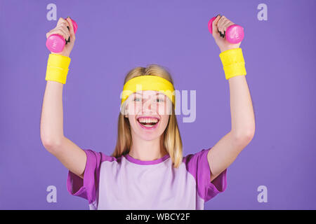 Vintage sport concept. Woman exercising with dumbbells. Easy exercises with dumbbells. Workout with dumbbells. Ultimate upper body workout for women. Girl hold dumbbells wear bright wristbands. Stock Photo