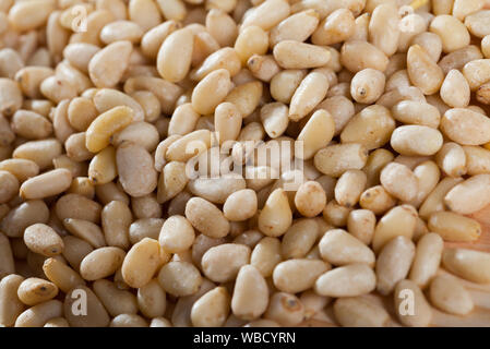 Lots of pine nuts scattered on wooden surface Stock Photo