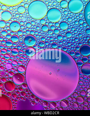 Multi-coloured bubble patterns formed by oil floating on water Stock Photo