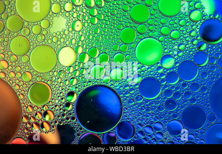 Multi-coloured bubble patterns formed by oil floating on water Stock Photo