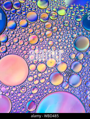 Multi-coloured bubble patterns formed by oil floating on water Stock Photo