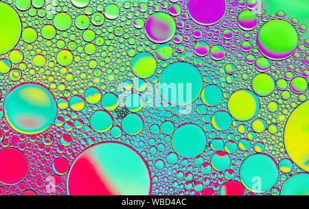 Multi-coloured bubble patterns formed by oil floating on water Stock Photo