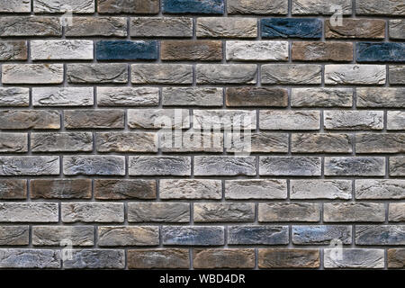 Vintage multi-colored bricks background, grunge texture. Old weathered brick wall. Decorative tile surface. Rough brickwork. Stock Photo
