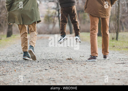 young beautiful family walking holding hands by city park Stock Photo