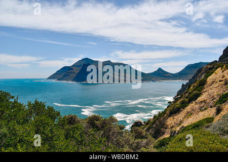 Hout Bay and suurounding mountains against sea and sky on summer day Stock Photo