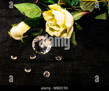 Yellow Rose With Cut Stones On Black Background Stock Photo