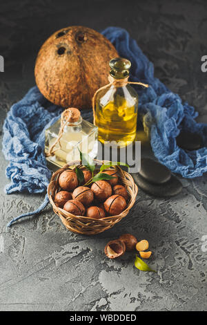 Natural macadamia and coconut oil in a glass bottles with macadamia nuts and cocnut. Use for Healthy Skin and Hair and Natural Healing Oil Treatment Stock Photo