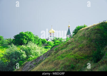 Little church with domes on top of the hill, cloudy weather. Stock Photo