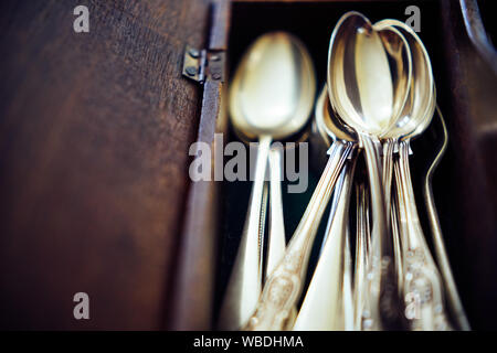 Vintage cutlery in vintage wooden box. Selective focus on spoons, close up.