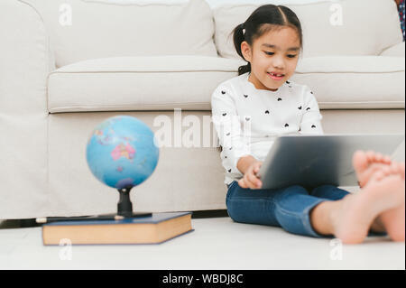 Happy Asian girl using laptop computer, concept for kid's art and home school. Stock Photo