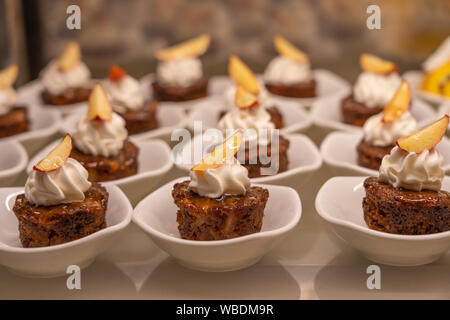 Well-decorated brownie topped with whipped cream and slice of apple Stock Photo