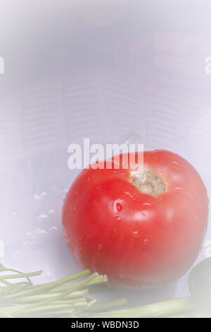 Freshly washed tomatoes, cucumbers and greens on a white table Stock Photo
