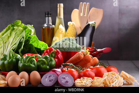 Fresh vegetables and cooking pot on kitchen table. Stock Photo