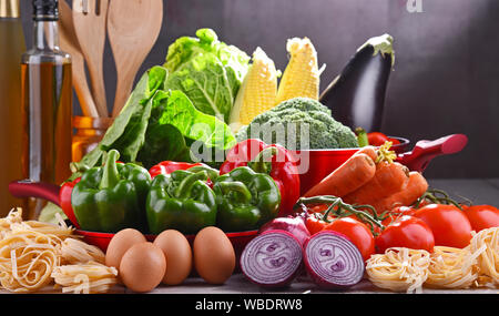Fresh vegetables and cooking pot on kitchen table. Stock Photo