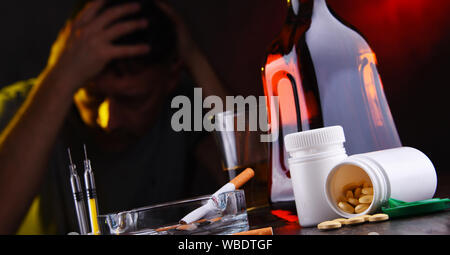 Addictive substances and the figure of a addicted man. Stock Photo