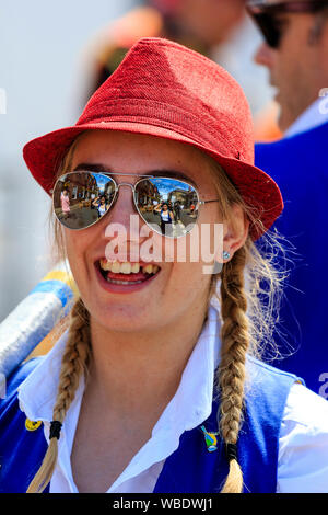 Sandwich folk and Ale Festival. Close up, head and shoulders, of young woman from Royal Liberty Morris, wears red hat and sunglasses, smiling, facing. Stock Photo