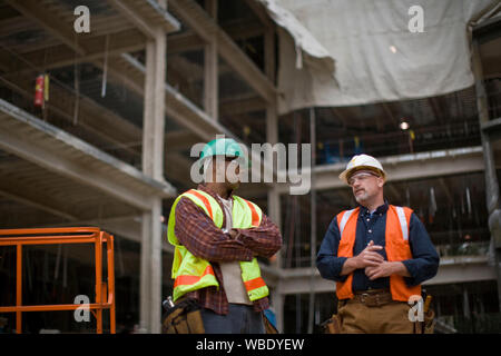 Two builders talking on a construction site Stock Photo