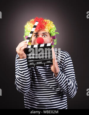 Funny clown with clipper box. Studio shot. Stock Photo