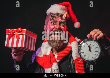 Halloween or christmas man devil hold present box and clock Stock Photo
