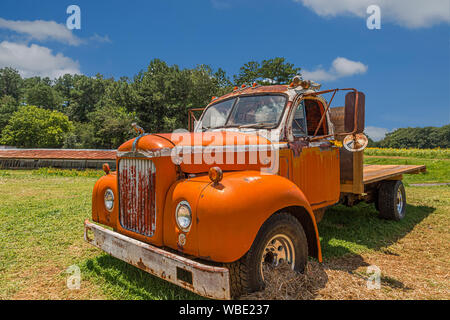 An old orange Mack truck on a working farm Stock Photo