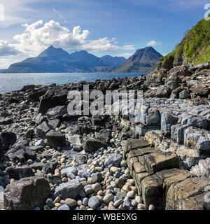 Black Cuillin Mountains on the Isle of Skye with Loch Scavaig and rocky shore of Glen Scaladal bay near Elgol in the foreground, Scotland, UK Stock Photo