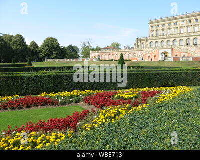 The palatial mansion at Cliveden built in 1666, with the colourful formal planting scheme on The Parterre in red & yellow for summer 2019 Stock Photo
