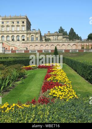 The palatial mansion at Cliveden built in 1666, with the colourful formal planting scheme on The Parterre in red & yellow for summer 2019 Stock Photo