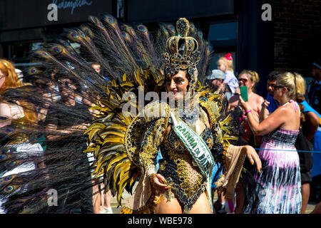 26 August 2019 - Samba dancer wearing costume with crown headdress, peacock feathers at Notting Hill Carnival on a hot Bank Holiday Monday, London, UK Stock Photo