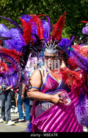 26 August 2019 - Dancer dressed up on feather headdress at the Notting Hill Carnival on a hot Bank Holiday Monday, London, UK Stock Photo