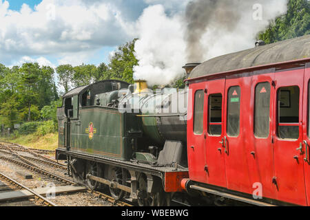 CRANMORE, ENGLAND - JULY 2019: Steam engine pulling a train departing from Cranmore Station on the East Somerset Railway. Stock Photo